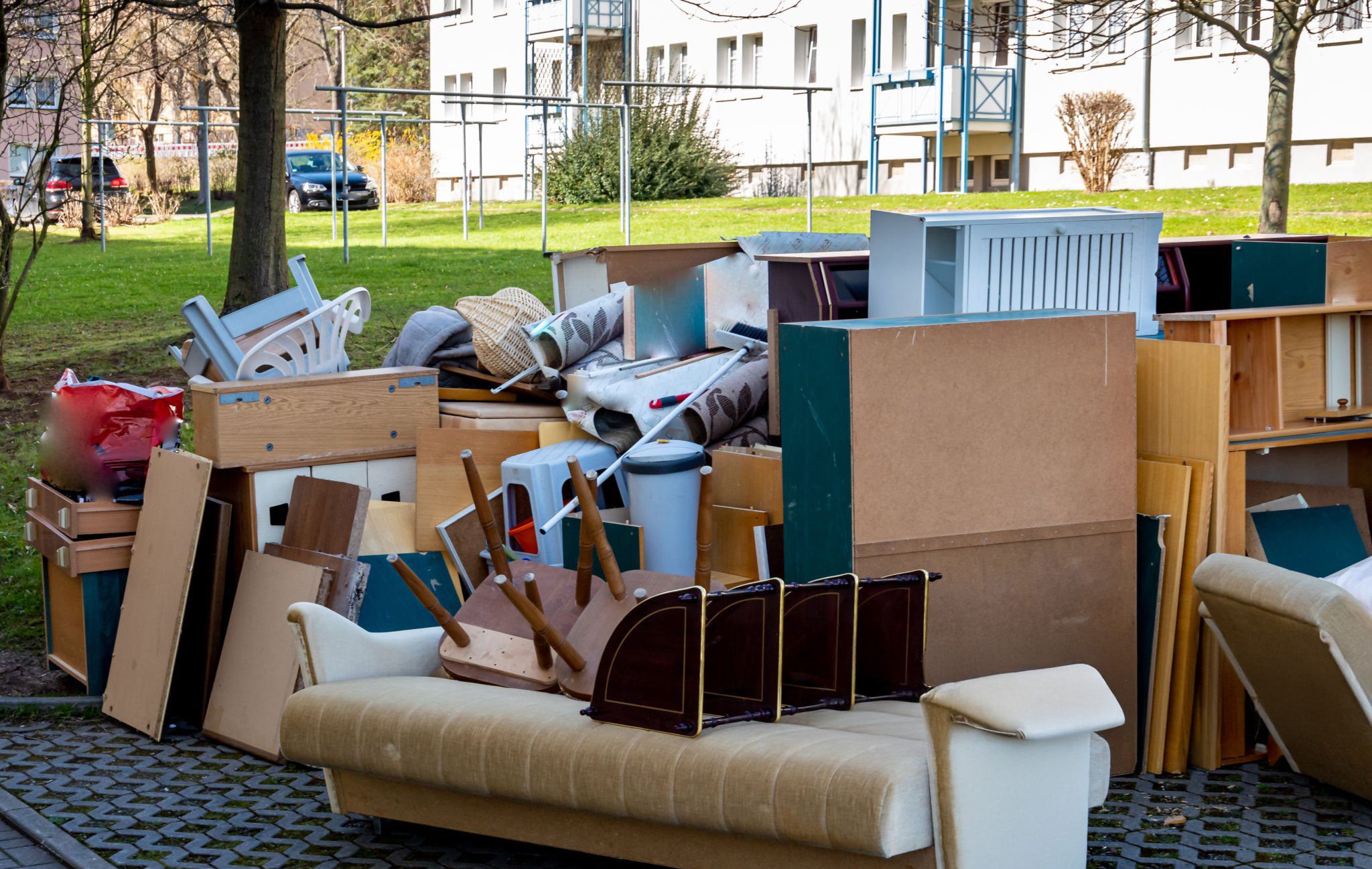 Bulk household waste on road curbside. Includes furniture, couches, dressers, general waste, and more.