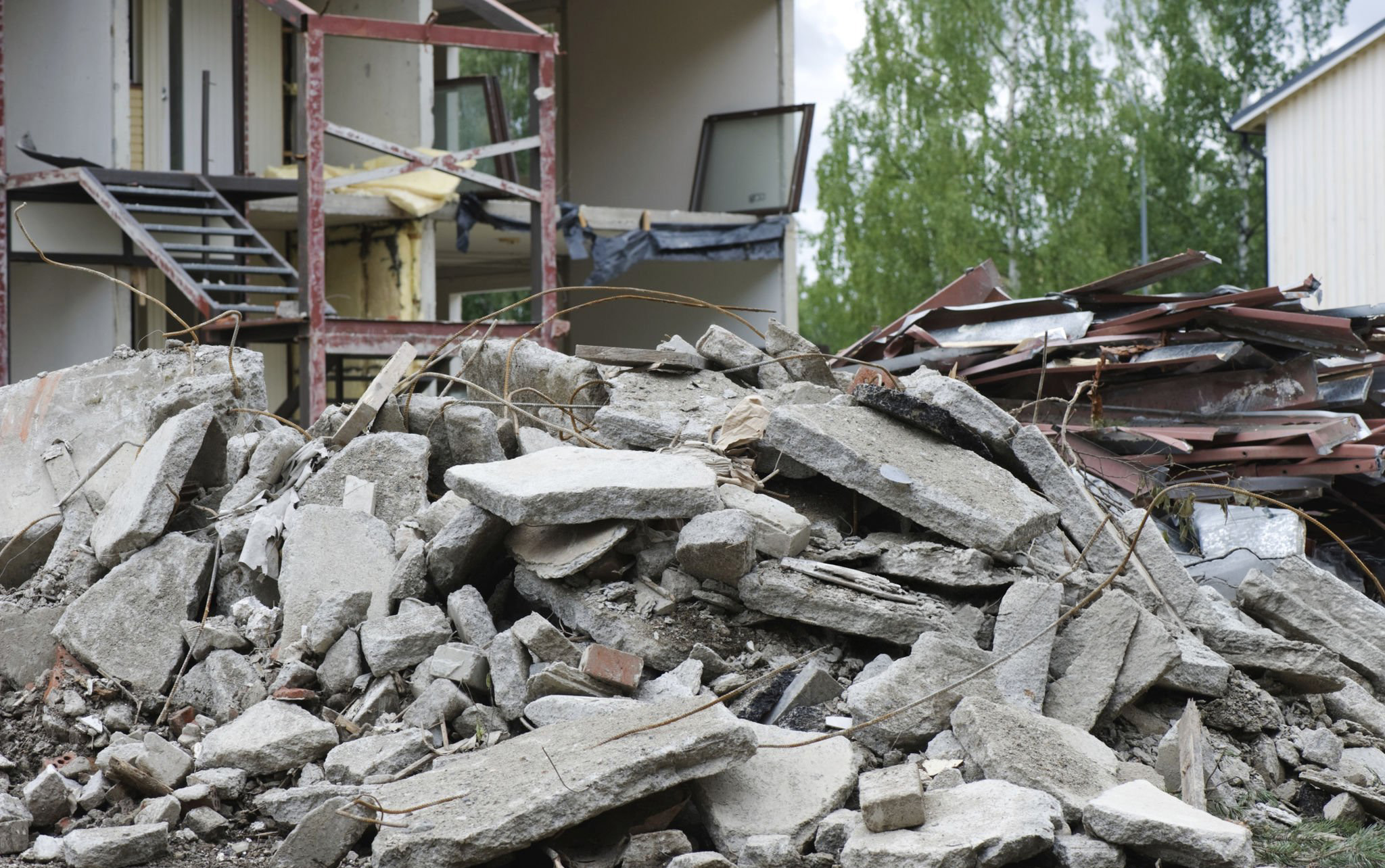 Pile of concrete in front of demolished residential property.
