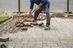 Contractor removing concrete brick pathway