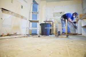 Man tearing out old kitchen during home renovations.