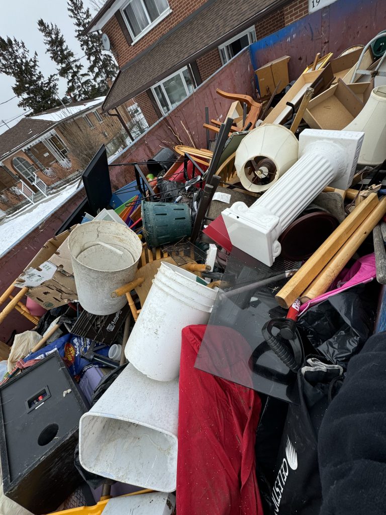 Safety-compliant dumpster loading by Elite Disposal Services for home renovation dumpster