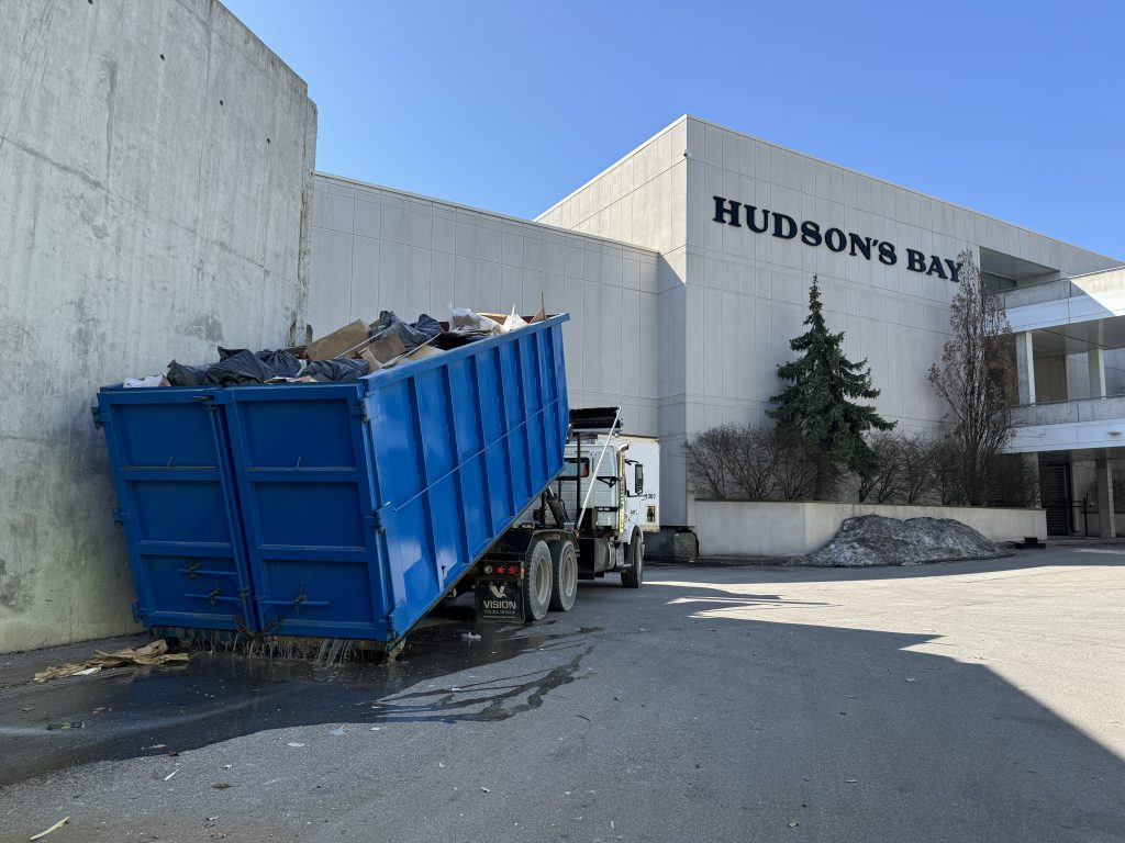 Professional junk removal team from Elite Disposal Services loading a dumpster after mall store renovation